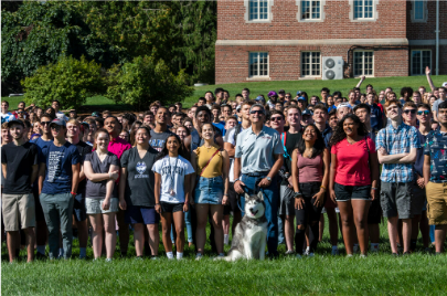 Students and faculty with Jonathan Husky smiling in a crowd.